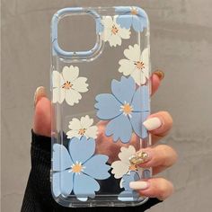 a woman's hand holding an iphone case with blue and white flowers on it