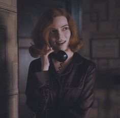 a woman is talking on the phone in an old fashioned room with wood paneling