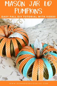 two orange and blue pumpkins sitting on top of a counter with text overlay that says mason jar lid pumpkins