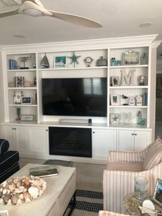 a living room filled with furniture and a flat screen tv mounted on a wall above a fireplace