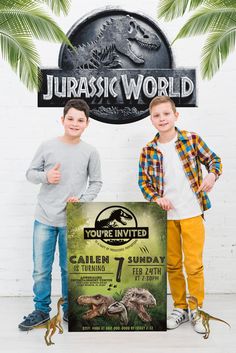 two young boys standing in front of a sign