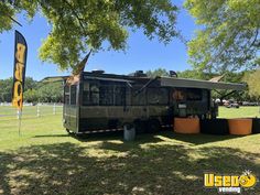 an rv is parked in the grass near a sign that says bbq on it