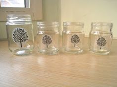 four glass jars with trees painted on them