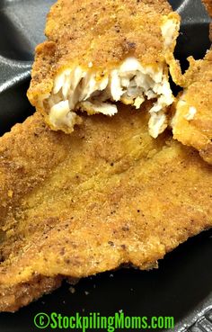 some fried food on a black plate with a bite taken out of the top one