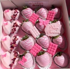 a pink box filled with lots of chocolate covered strawberries and heart shaped candies