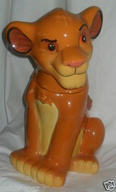 a ceramic lion figurine sitting on a white background