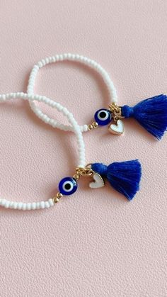 Evil eye bracelet is made with high quality beads that will not fade or tarnish. It is made with glass seed beads and 14k gold filled spacers. This bracelet can be ordered with or without tassel + heart charm. The listing is for ONE bracelet. For custom orders or questions please feel free to send us a message. Thank you🤗 White Friendship Bracelets With Evil Eye, White Evil Eye Friendship Bracelets, White Round Beaded Evil Eye Bracelet, White Beaded Round Evil Eye Bracelet, White Spiritual Beaded Bracelets With Heart Beads, White Evil Eye Beaded Bracelets, Bohemian White Evil Eye Bracelet For Friendship, White Bohemian Evil Eye Bracelet For Friendship, Adjustable Evil Eye Charm Bracelet