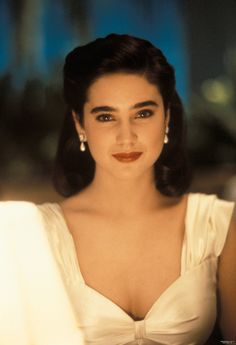 a close up of a person wearing a white dress and smiling at the camera with her hands on her hips