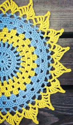 a blue and yellow doily on a wooden surface