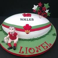 there is a cake that has been decorated with a football ball and the name wales on it