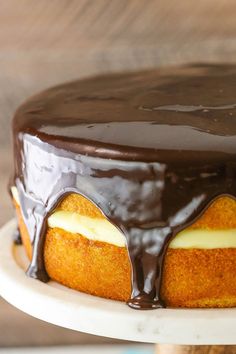 a cake with chocolate icing on top and white frosting around the edges is sitting on a plate