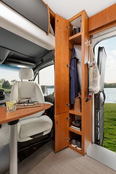 an interior view of a camper van with the door open and shelves full of items