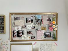 a bulletin board with pictures and flowers on it next to a mirror, framed photograph