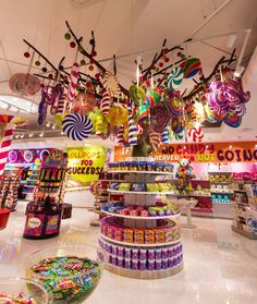 a store filled with lots of candy and lollipops hanging from the ceiling