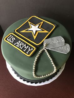 a cake decorated with an army emblem and a star on top is sitting on a table