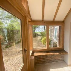 the inside of a house with windows and brick flooring on either side of it