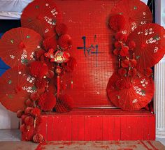 two red umbrellas sitting next to each other on top of a wooden bench in front of a wall