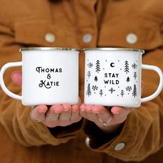 two white coffee mugs that say, thomas and kate are holding in their hands