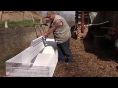 a man standing next to a white bird cage