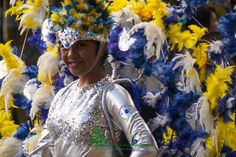 a woman dressed in silver and yellow feathers