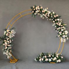 an arch decorated with white flowers and greenery