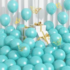 a white box surrounded by blue balloons with gold butterflies on them and a golden bow