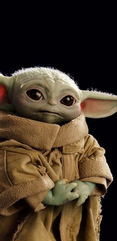 a baby yoda doll is shown in front of a black background