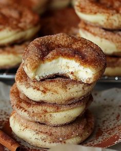 cinnamon sugar donuts stacked on top of each other with cinnamon sticks in the background