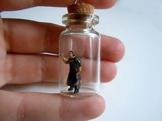 a tiny figurine is in a glass bottle