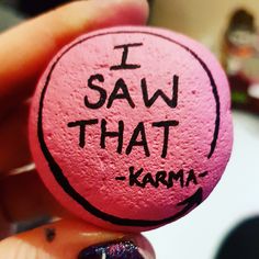 a person holding a rock with writing on it that says i saw that karmi