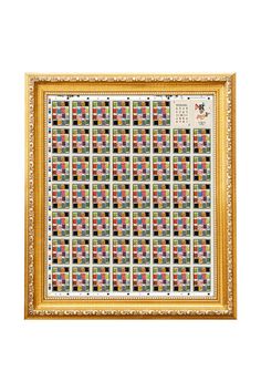 a gold frame holding a quilt with squares on it and numbers in the middle,