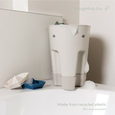 a white toilet sitting on top of a bathroom counter next to a blue toothbrush holder