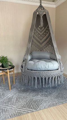 a hammock chair in the corner of a room with a rug on the floor