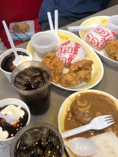 a table topped with plates of food and cups filled with ice cream, sauces and jelly