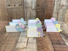 dinosaur themed place cards on wooden background