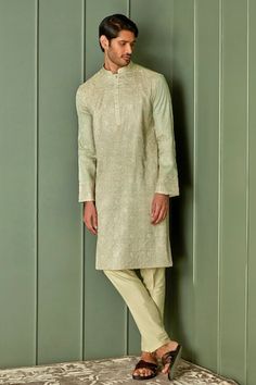 Olive green tussar silk kurta with all over floral jaal pattern and tonal resham embroidery. Paired with contrast pyjama. - Aza Fashions Pista Green Kurta With Naqshi Traditional Drape, Pista Green Kurta With Naqshi In Traditional Style, Festive Pista Green Kurta With Naqshi, Traditional Pista Green Kurta With Naqshi, Traditional Naqshi Kurta In Pista Green, Green Jamawar Traditional Wear With Naqshi Details, Semi-stitched Pista Green Kurta With Naqshi Detail, Green Jamawar Traditional Wear With Naqshi, Pista Green Traditional Wear With Naqshi For Eid