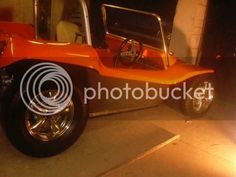 an orange and black car parked in a garage