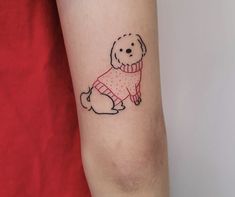 a small dog with a sweater on its body is shown in the upper arm tattoo