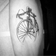 a black and white photo of a bike on someone's leg with the word love written in it