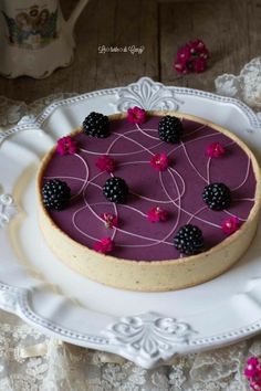 a cake on a plate with blackberries and raspberries in the top layer