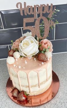 a birthday cake with strawberries and flowers on top