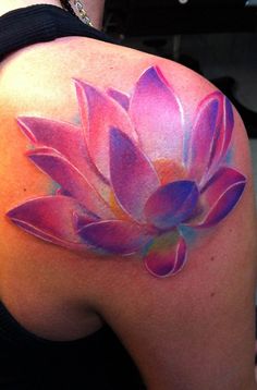 a woman's back shoulder with a pink flower painted on it