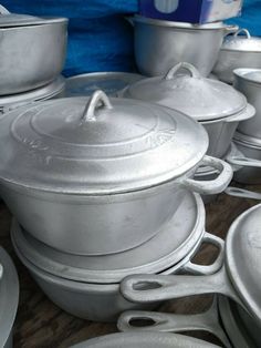 many pots and pans are stacked on top of each other in the middle of a table