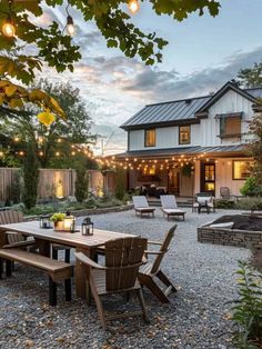 an outdoor dining area is lit up by string lights and surrounded by graveled stones