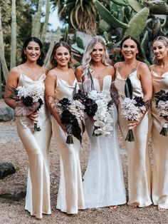 a group of women standing next to each other in front of cacti plants