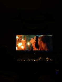 the screen is lit up in the dark and shows an image of a woman with her eyes closed