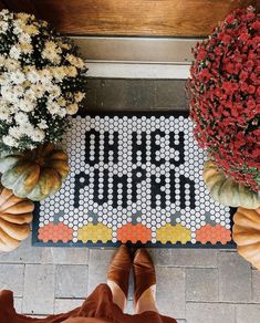 a tiled welcome mat with pumpkins and gourds