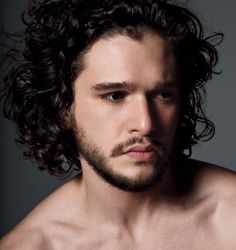 a shirtless man with long curly hair