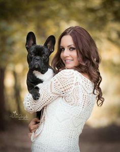 a woman holding a small black and white dog