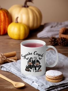 a cup of tea sits on a napkin next to some pumpkins and cinnamon sticks